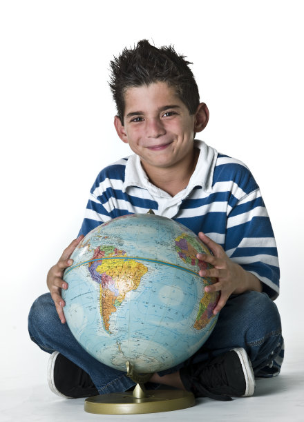 儿童摆姿势与一个小桌面世界地球仪图片下载