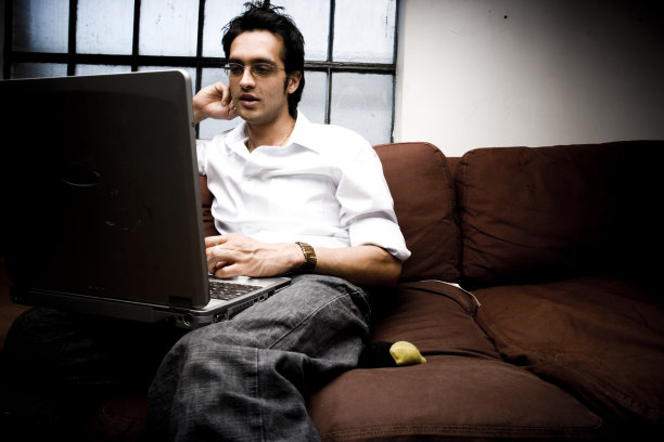 印度电脑人在沙发上工作图片下载