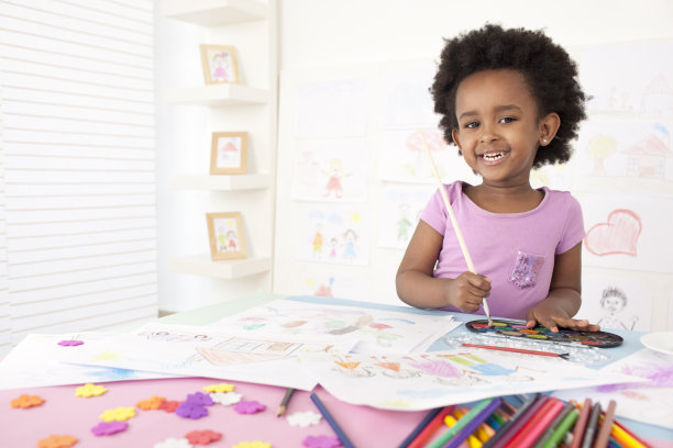 微笑的小女孩在画画。图片下载