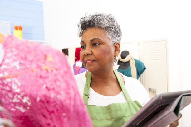 企业家:年长非洲体面妇女穿着围裙检查精品库存图片下载