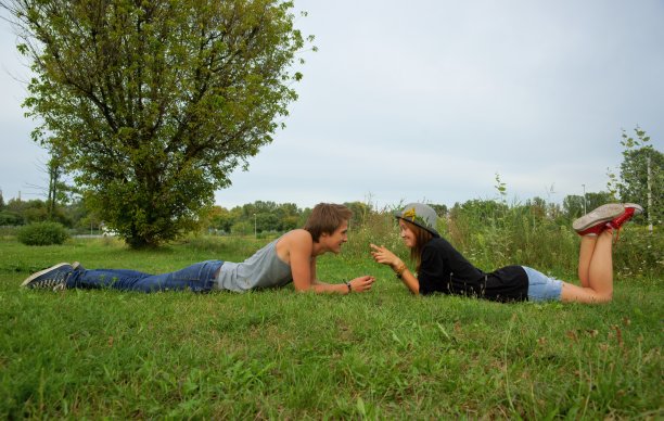 男孩和女孩，青少年躺在草地上图片下载