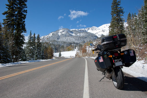 摩托车停在落基山脉积雪的公路上。图片下载