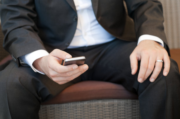 一个商人使用智能手机的特写图片下载