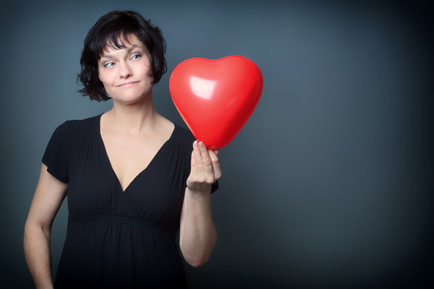 女人手里拿着一个心形气球，乐乐图片下载