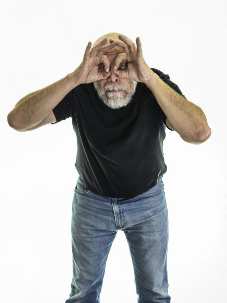 高级成年男子双目透过卷曲的手指窥视图片下载