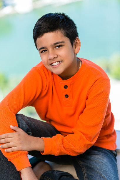 可爱的穿着随意的男孩坐在户外图片下载