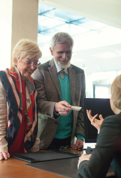 一对老年夫妇在酒店前台付账图片下载