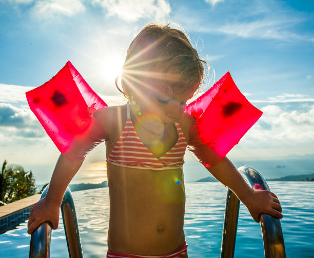 在游泳池里戴着手臂环的小女孩图片下载