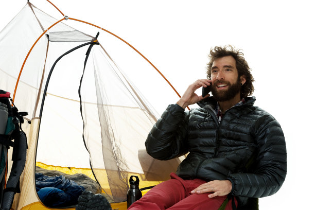 微笑的徒步旅行者坐着用手机聊天图片下载