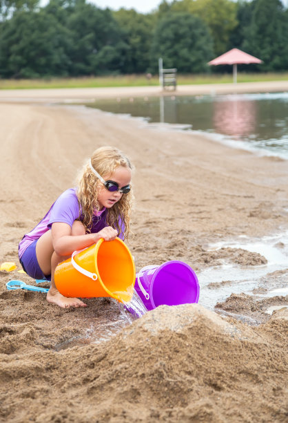 小女孩在沙滩上玩沙子图片下载