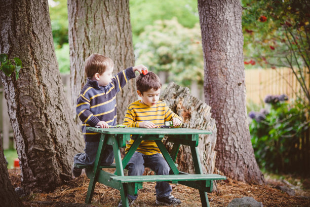 两个男孩在外面玩玩具车图片下载