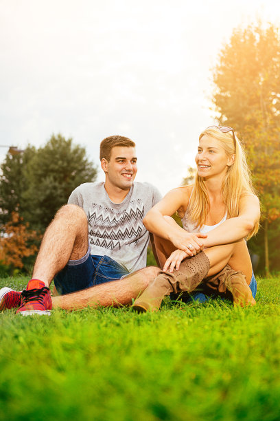 可爱的金发女孩和英俊的年轻人在公园放松图片下载