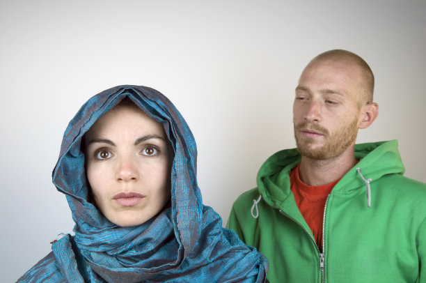 男人看着戴头巾的年轻女人图片下载