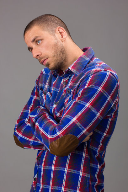 年轻人皱着眉头，双臂交叉图片下载