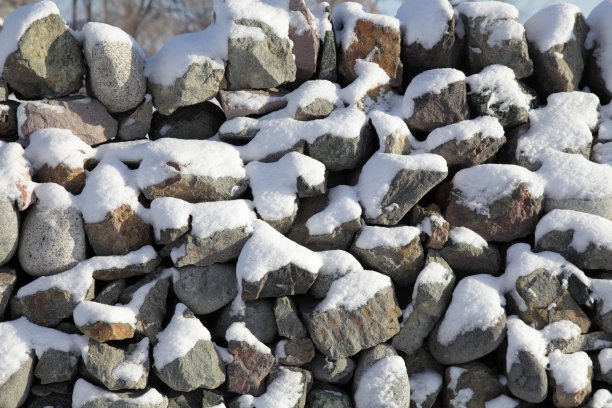 特写干燥的石头(没有砂浆)墙在冬天。图片下载