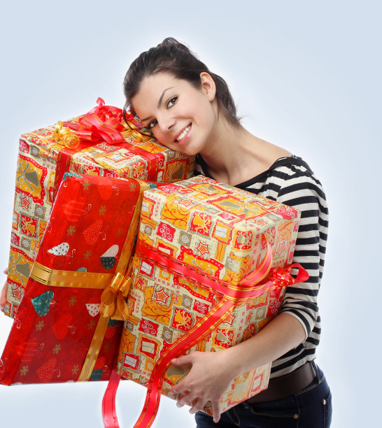 美丽快乐的女孩微笑着，在蓝色的背景下拿着礼物，图片下载