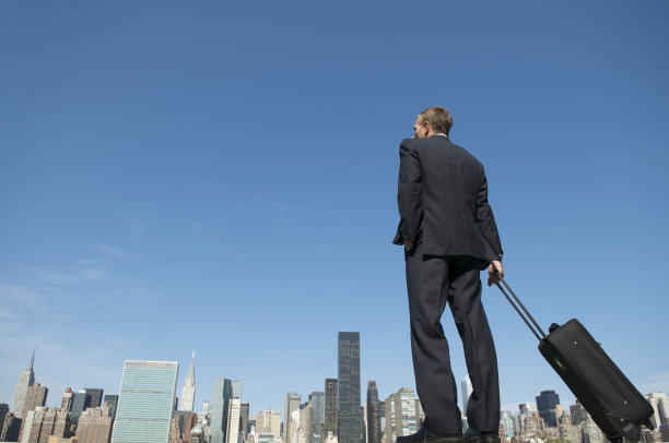 商人站在城市天际线上手提箱图片下载
