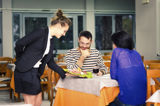 女服务员为一对年轻夫妇端上一道意大利菜图片下载