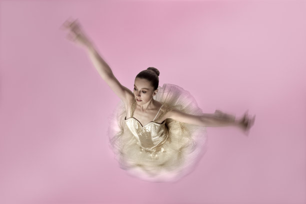 芭蕾舞者在粉红色上旋转图片下载