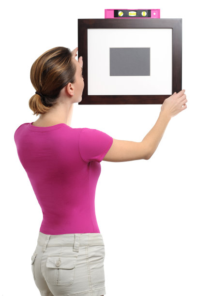 年轻女子挂画框水平在白色图片下载