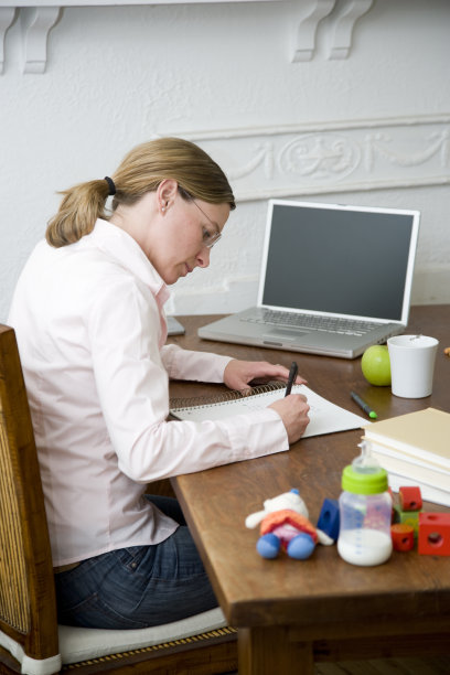 年轻的妈妈在家工作。图片下载