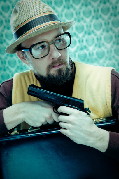 秘密交叉处理间谍拿着手枪手枪和公文包图片下载