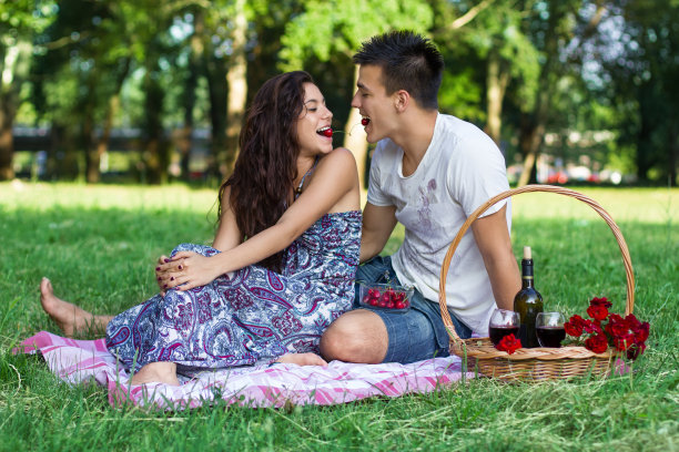 年轻幸福的夫妇在野餐吃樱桃图片下载