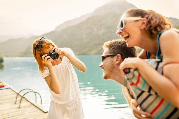 一个女人在给一对夫妇拍照图片下载