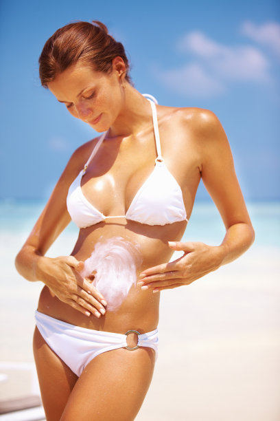 在胃上涂乳液的女人图片下载