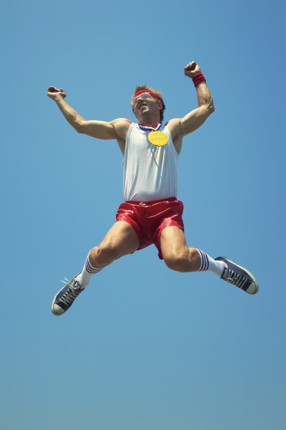 金牌书呆子运动员在蓝天上跳跃图片下载