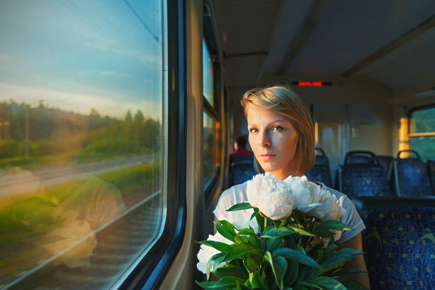 在火车上拿着花的年轻女子图片下载