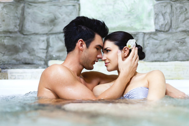 热情洋溢的情侣在水疗中心的热水浴缸里图片下载