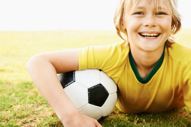 足球运动员微笑着躺在球场上图片下载