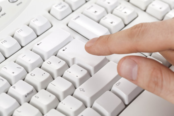 男人的手指触摸键盘上的输入键图片下载