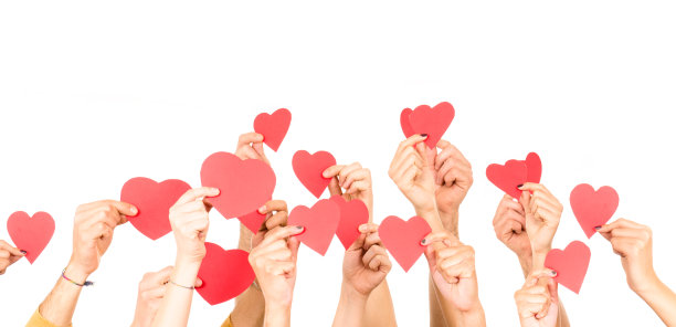 人们捧着一颗心的形状孤立在白色之上素材图片
