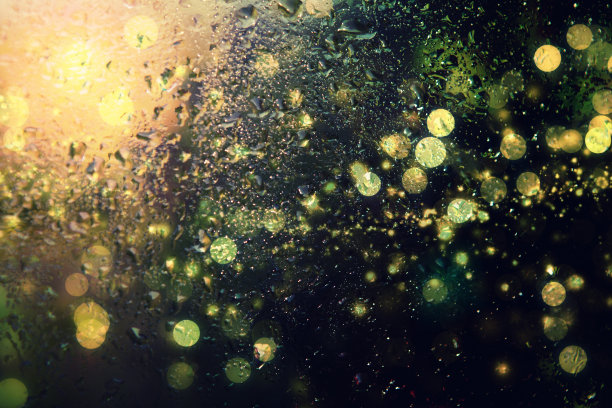 玻璃表面的雨滴和模糊的灯光图片下载