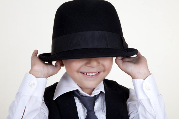 害羞的男孩拿着黑帽子图片下载