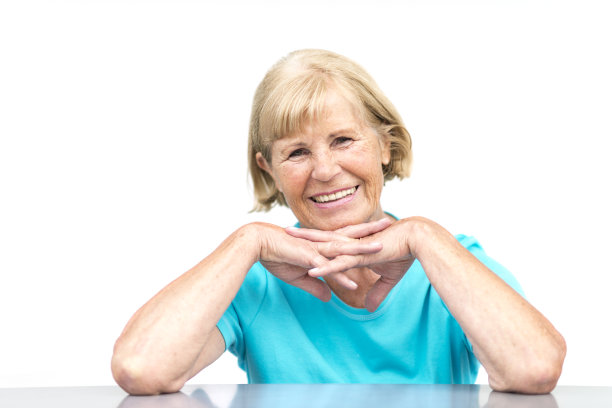 微笑着靠在桌子上的资深女士图片下载