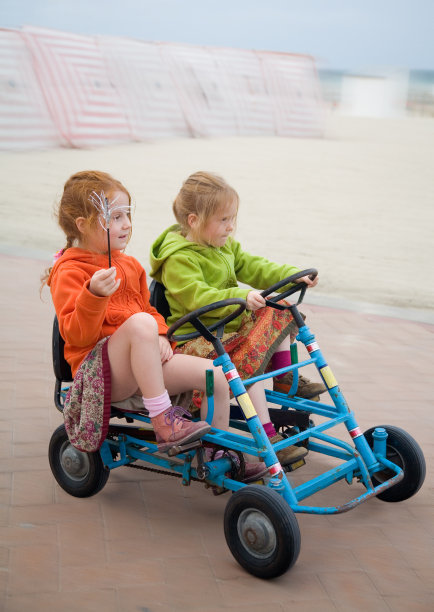 两个女孩在沙滩上玩卡丁车图片下载