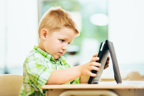 学前班的小男孩用着数码平板电脑图片下载