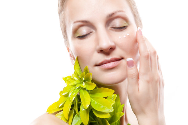 在脸上涂抹保湿霜的女人图片下载