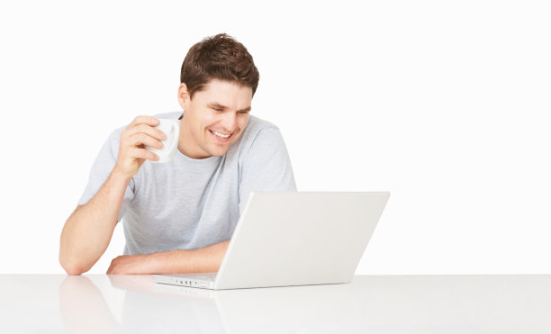 快乐的家伙一边喝咖啡一边用笔记本电脑图片下载