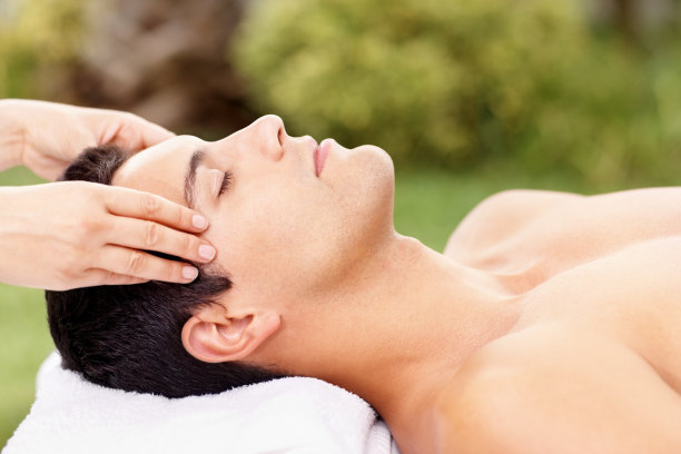 在户外水疗中心享受轻松的头部按摩的男性图片下载