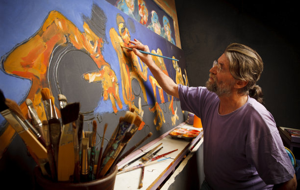 艺术家工作与艺术用品在前面的大型绘画图片下载