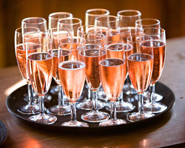 桌上放着粉红色的香槟，黑色的托盘图片下载