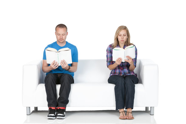 一对夫妇坐在沙发上看书图片下载