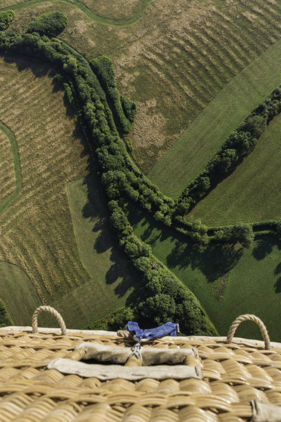 热气球在绿色田野上空高高飞翔图片下载