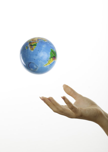 手把地球仪抛在白色的地面上图片下载