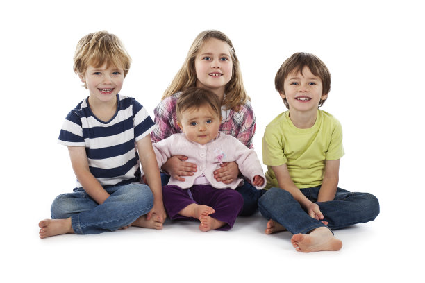 四个孩子坐在白色的背景上微笑图片下载