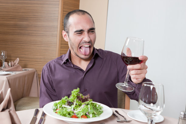 年轻男子拿着一杯劣质葡萄酒图片下载